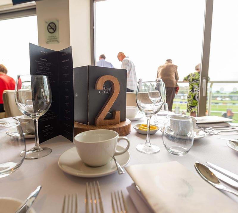 Close up on a table in Royal Crescent Suite set up with glasses, plates, and menus.
