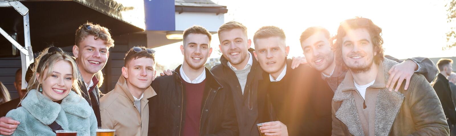 A large group of friends enjoy the races at Bath