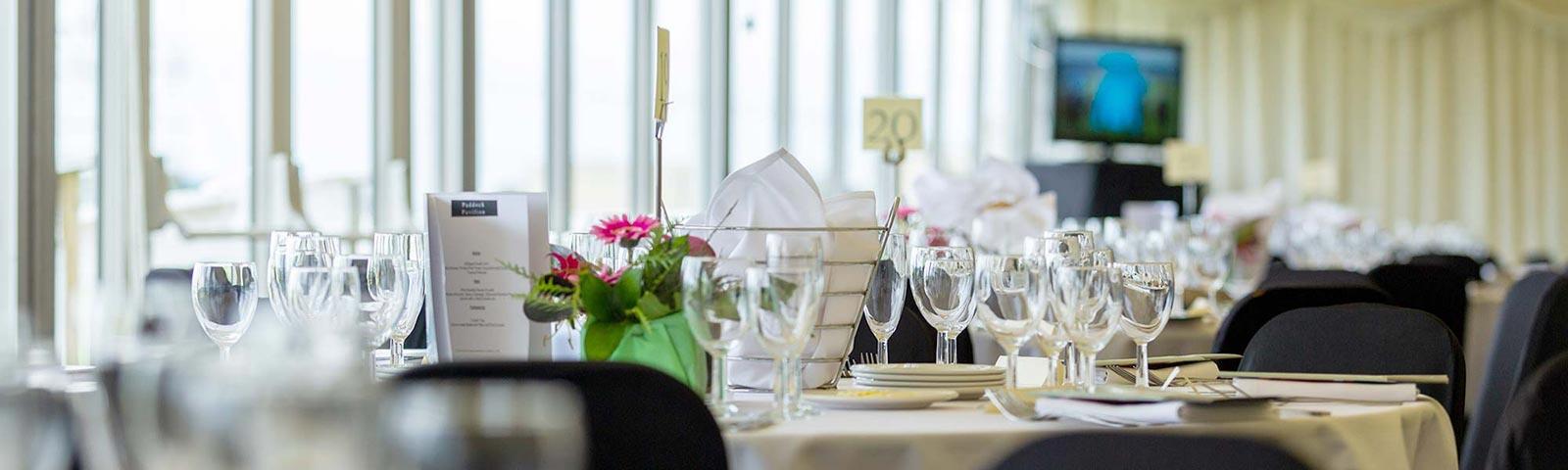 Close up on a table in restaurant set up with glasses, plates, menus.
