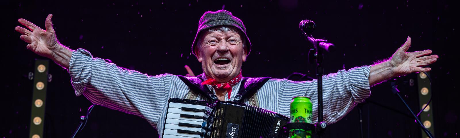 The Wurzels singer stood on stage smiling with his arms out to his side