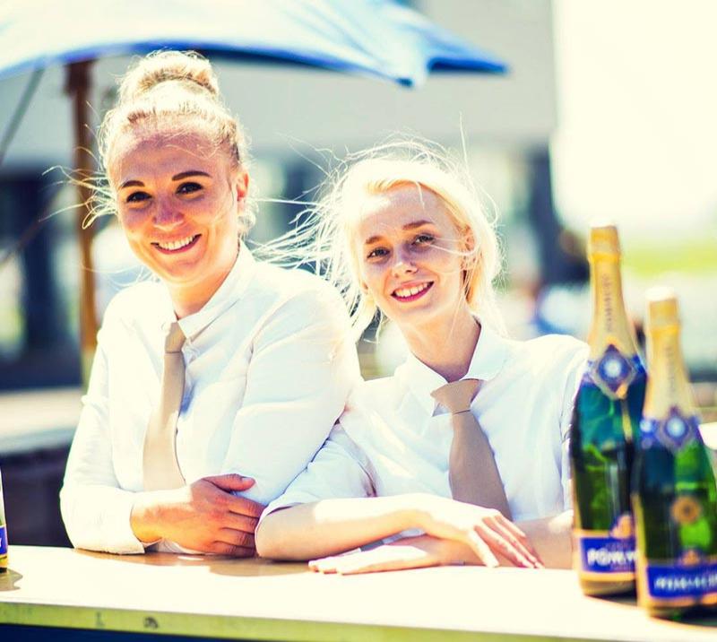 Two waitresses standing behind a bar counter.