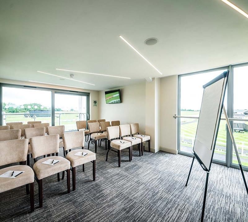 Private room with rows of chairs and a whiteboard in front, set up for a meeting.