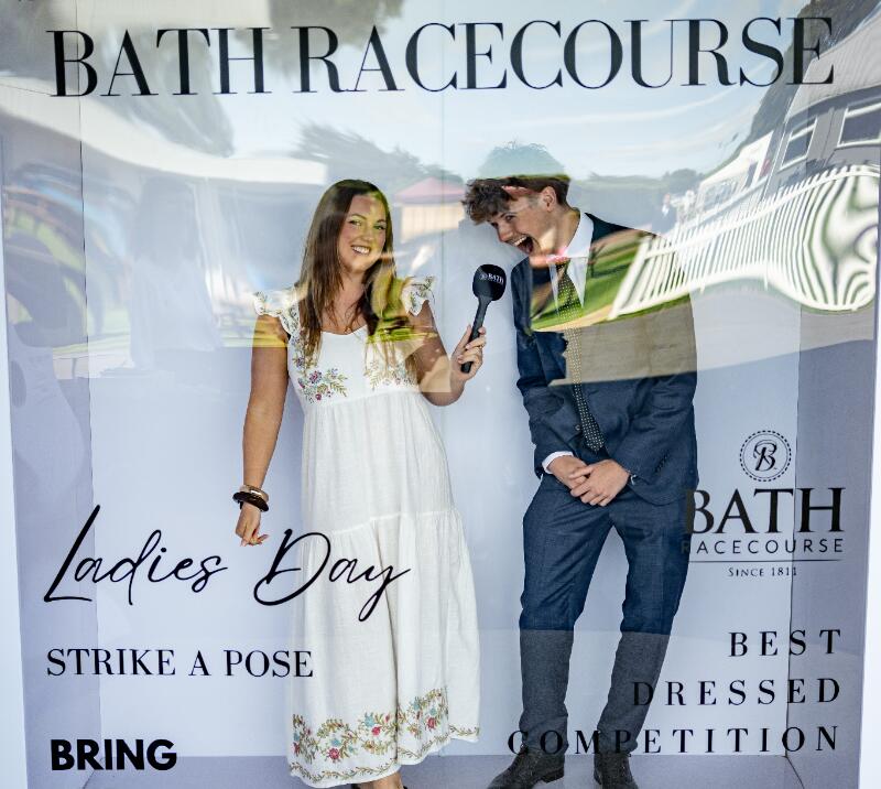 Two race goers pose in a picture box at Bath Racecourse