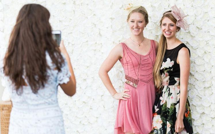 Two ladies posing for a photo during a raceday at Bath Racecourse.