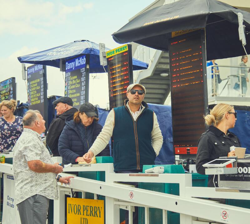 A line of bookmakers and their odds boards at Bath Racecourse
