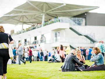 Crowds gathered on the Bath racecourse grounds during a raceday.