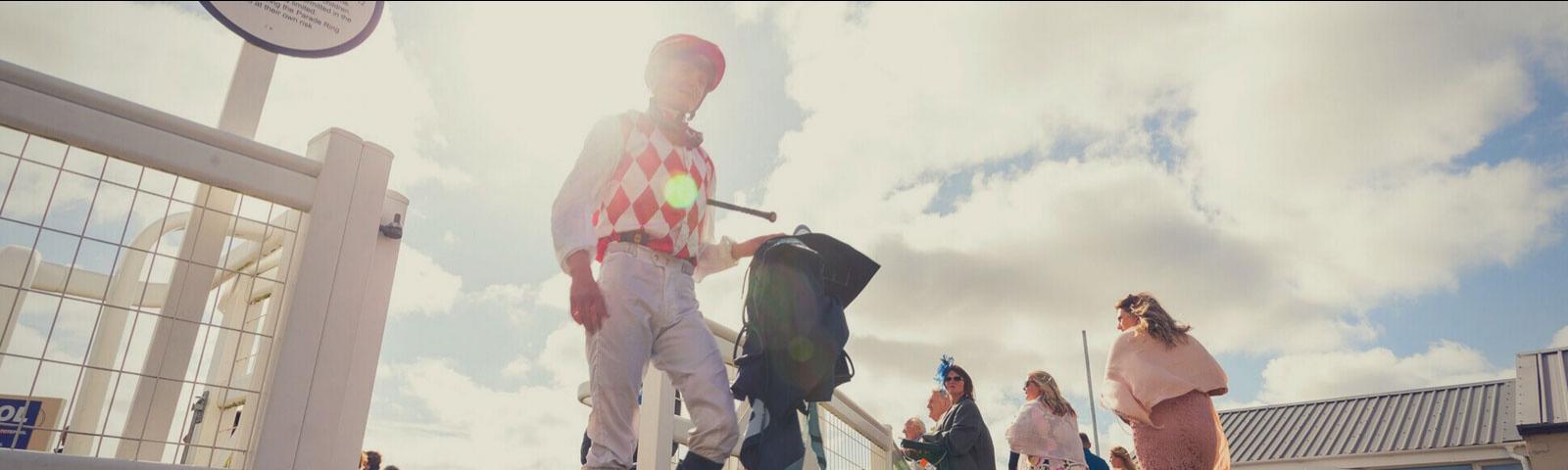 Jockey walking through parade ring at Bath Racecourse.