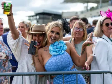 Two ladies at Bath Races pose in front of the crowd